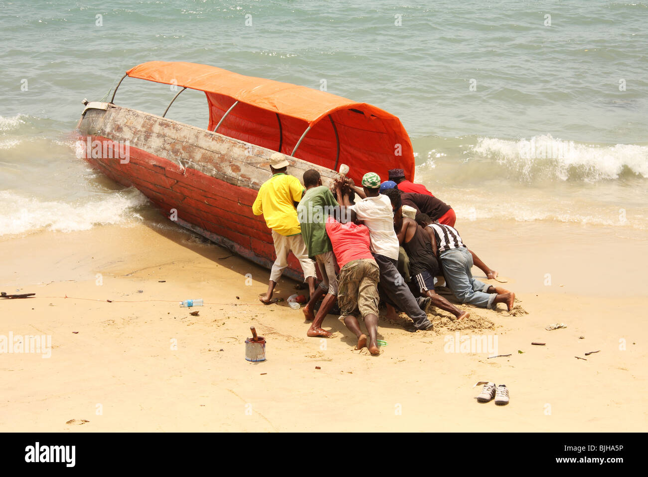 Launching a boat from Stone Town seafront Zanzibar Stock Photo