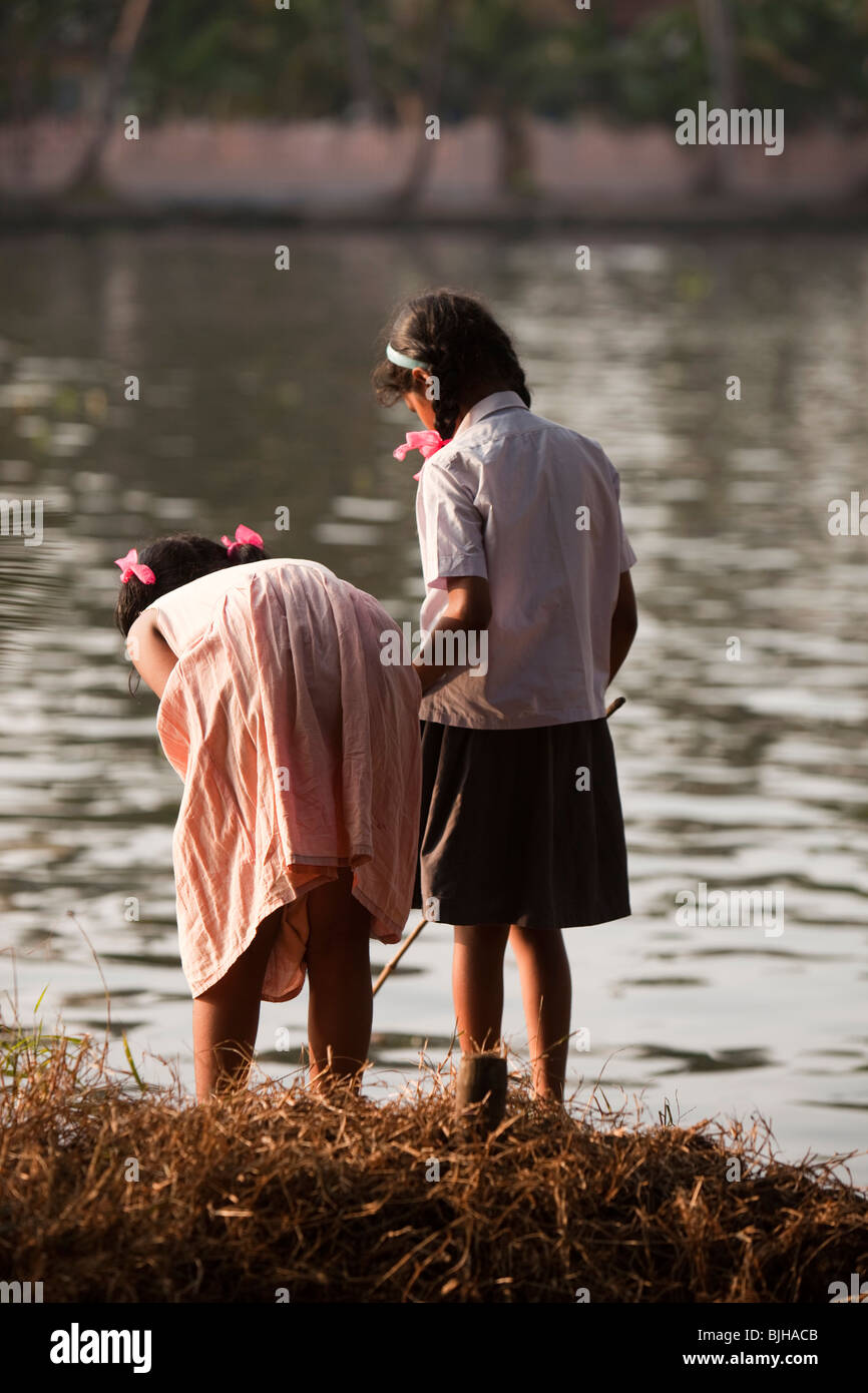 India, Kerala, Alappuzha, Chennamkary, backwaters, young girls fishing in shallows near riverbank Stock Photo