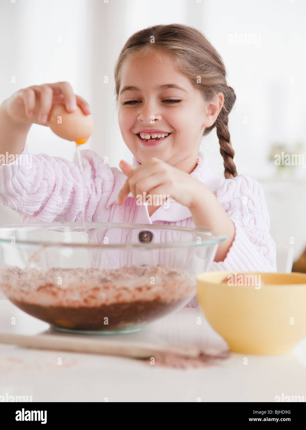 Young girl cracking egg Stock Photo