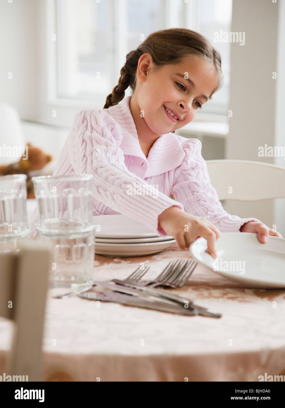 Young girl setting table Stock Photo