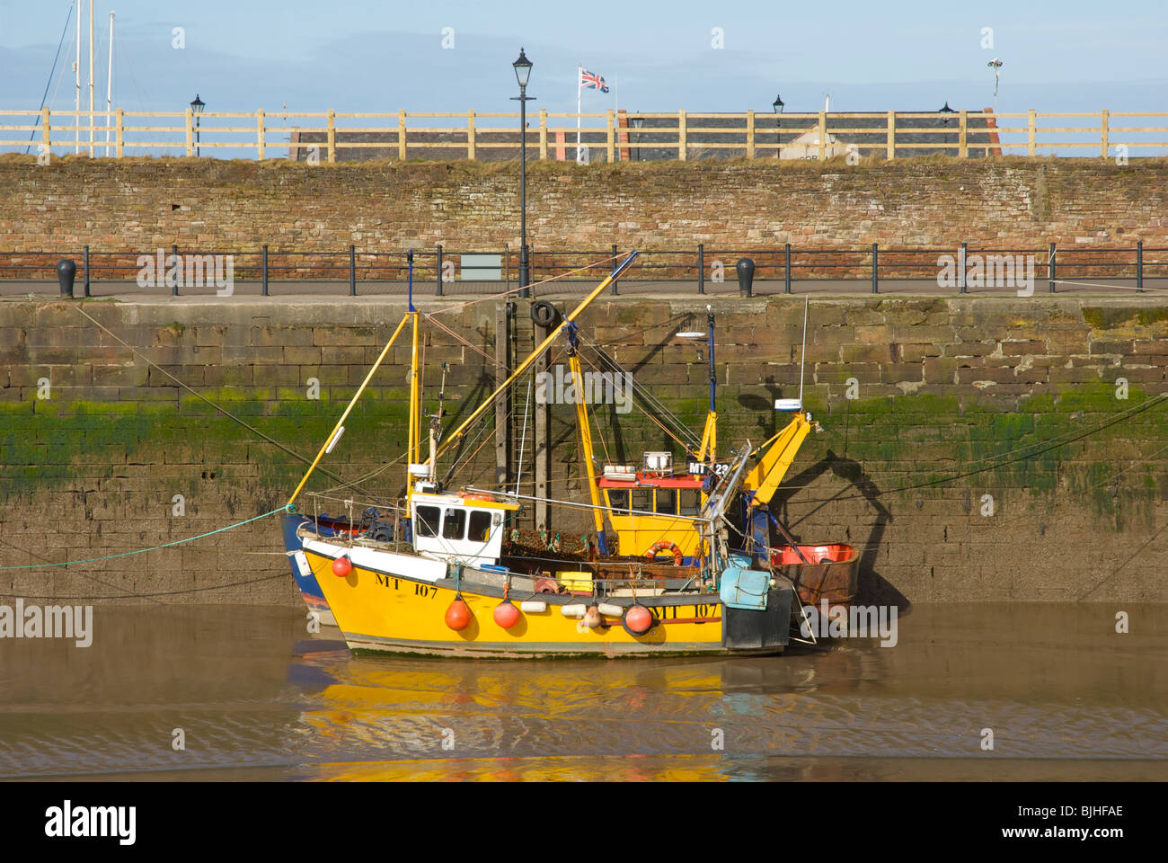 Fishing boats at low tide in Maryport harbour, West Cumbria, England UK