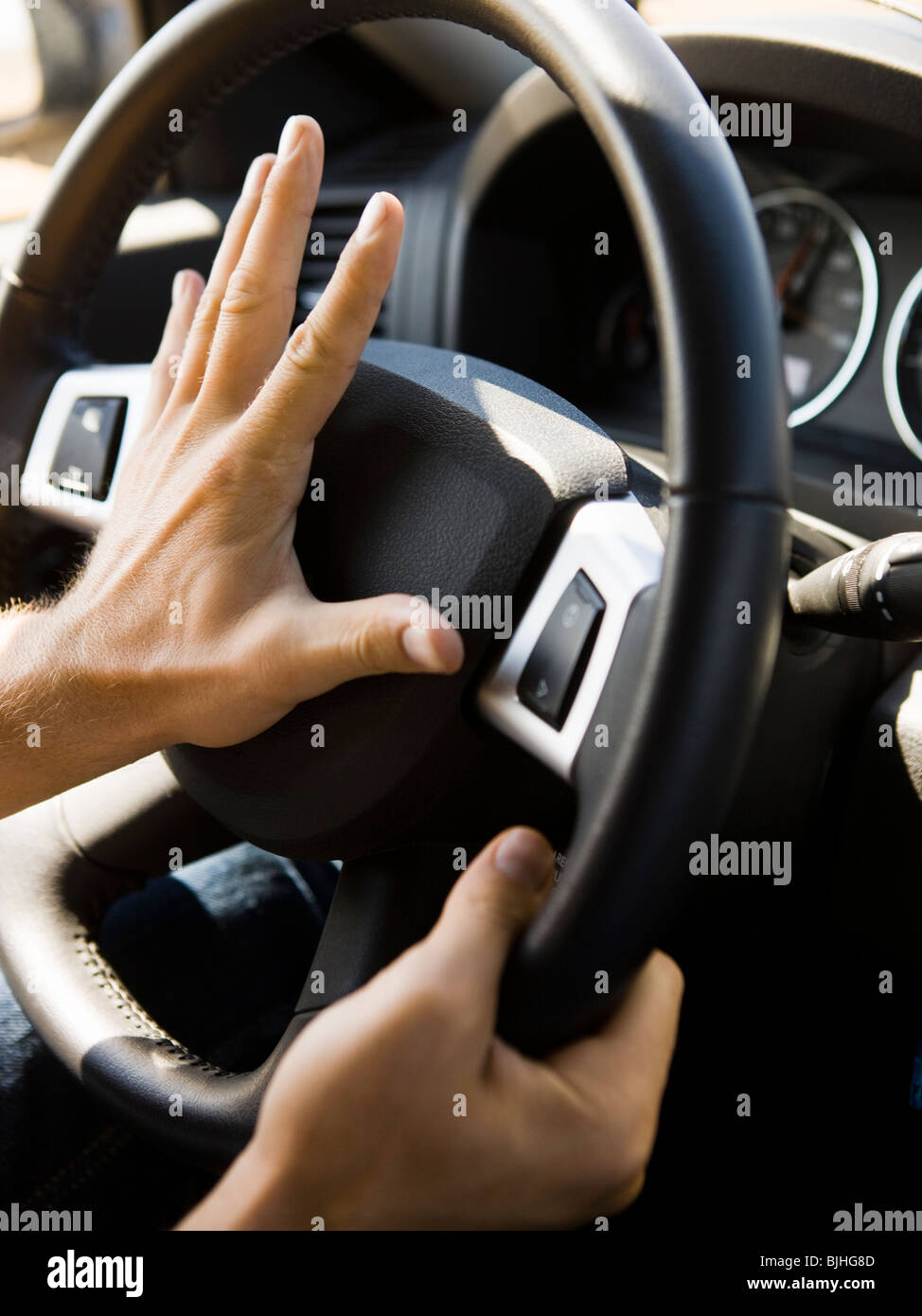 hands on the steering wheel hitting the horn Stock Photo Alamy
