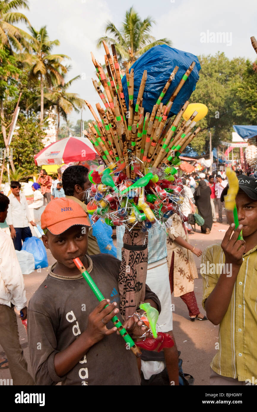 India, Kerala, Kanjiramattom Kodikuthu Moslem festival, boys selling flutes and cheap souvenirs outside mosque Stock Photo