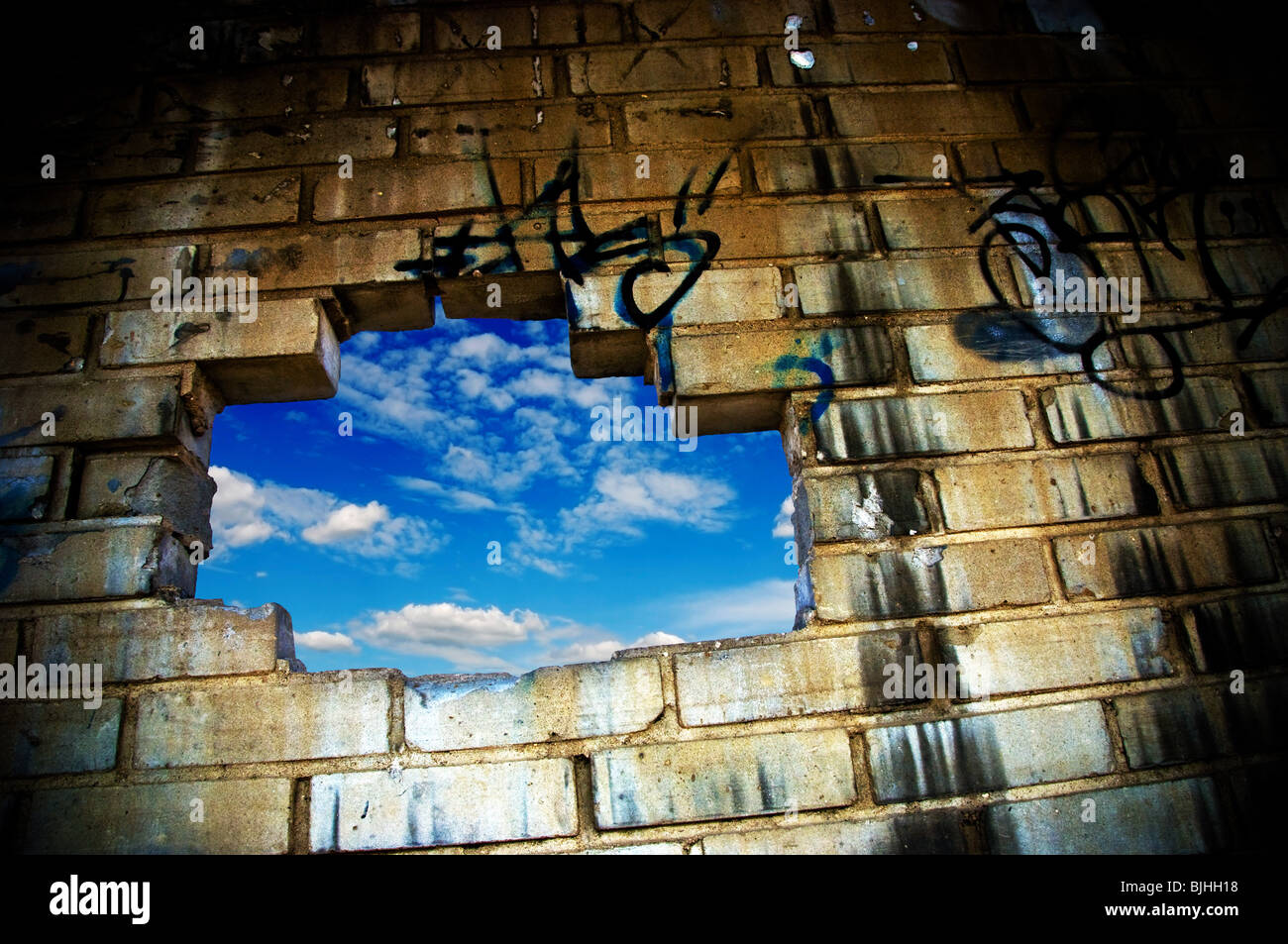 hole in a wall, blue sky seeing through Stock Photo