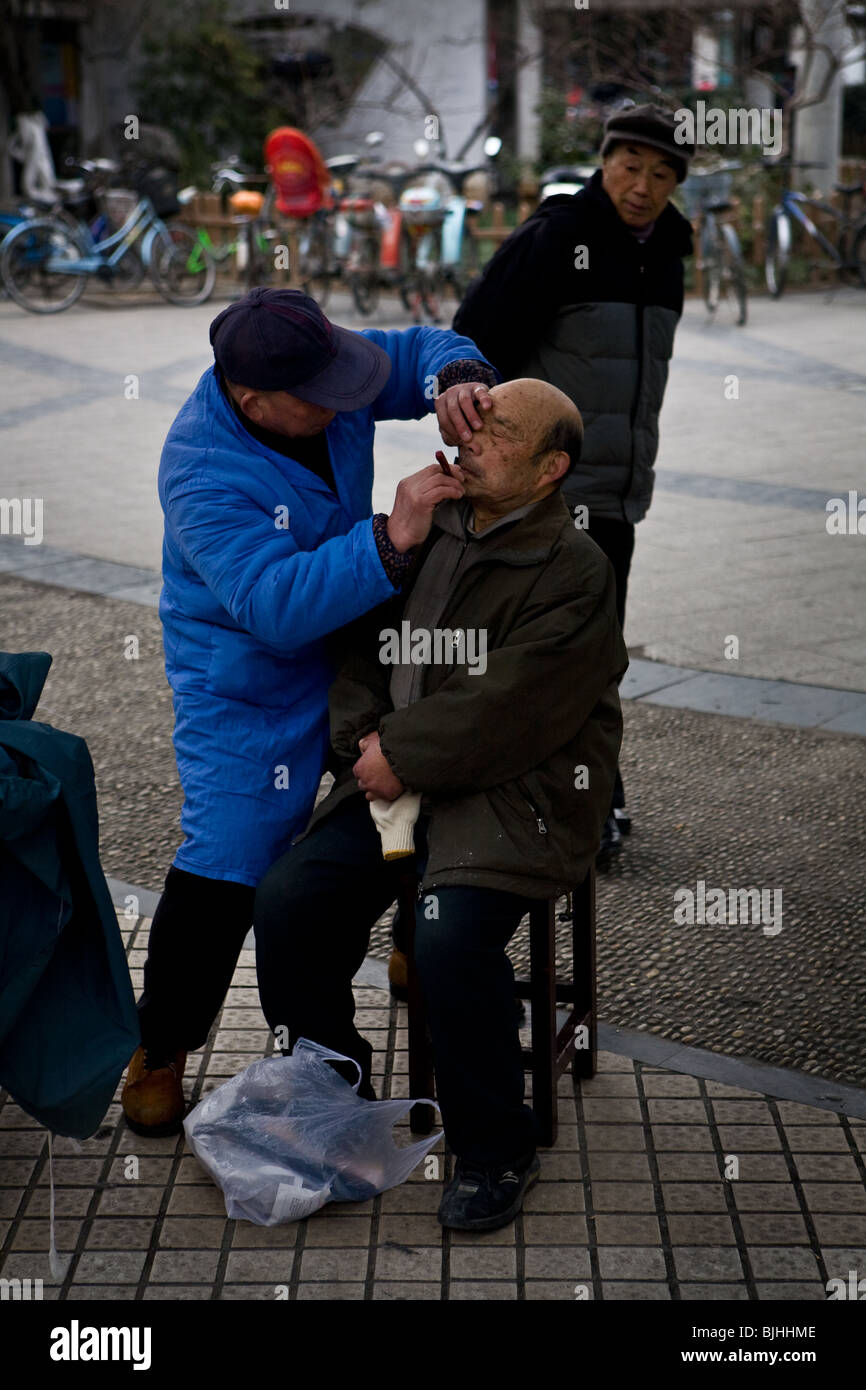 Man receiving shave. Nanjing, Jiangsu, China. Stock Photo