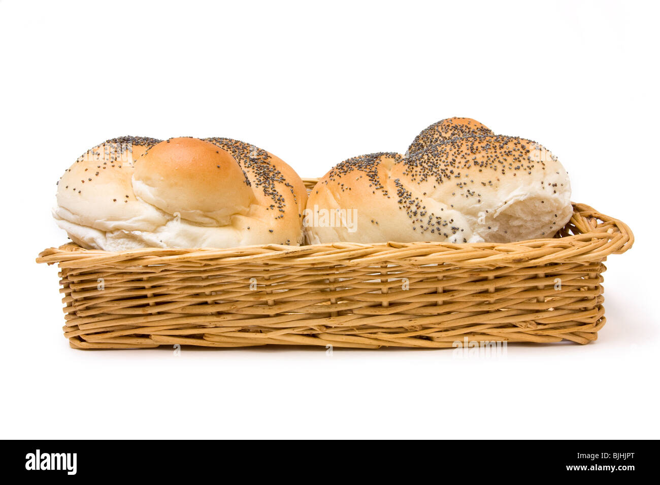 Seeded bread roll in wicker basket from low viewpoint isolated against white background. Stock Photo