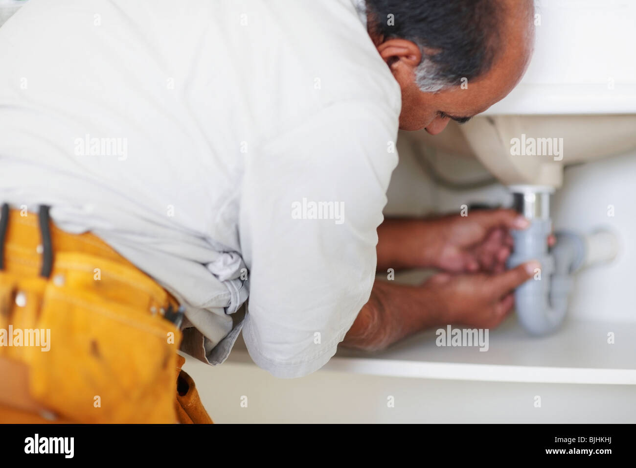 Plumber fixing sink Stock Photo