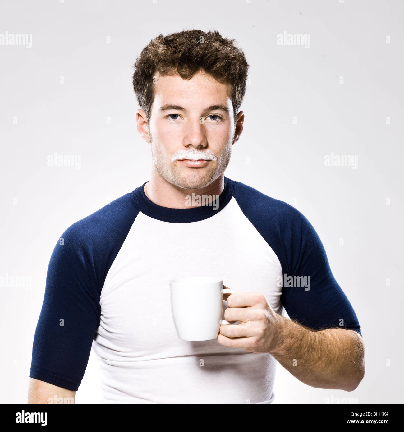 man with a milk moustache holding a white mug Stock Photo