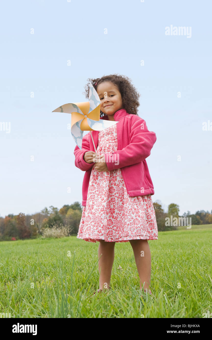 Girl playing with toy windmill Stock Photo