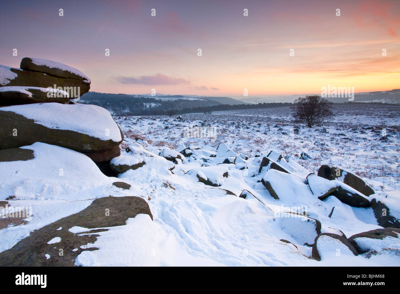 Sunset from a snowy Owler Tor in the Peak District National Park Stock Photo