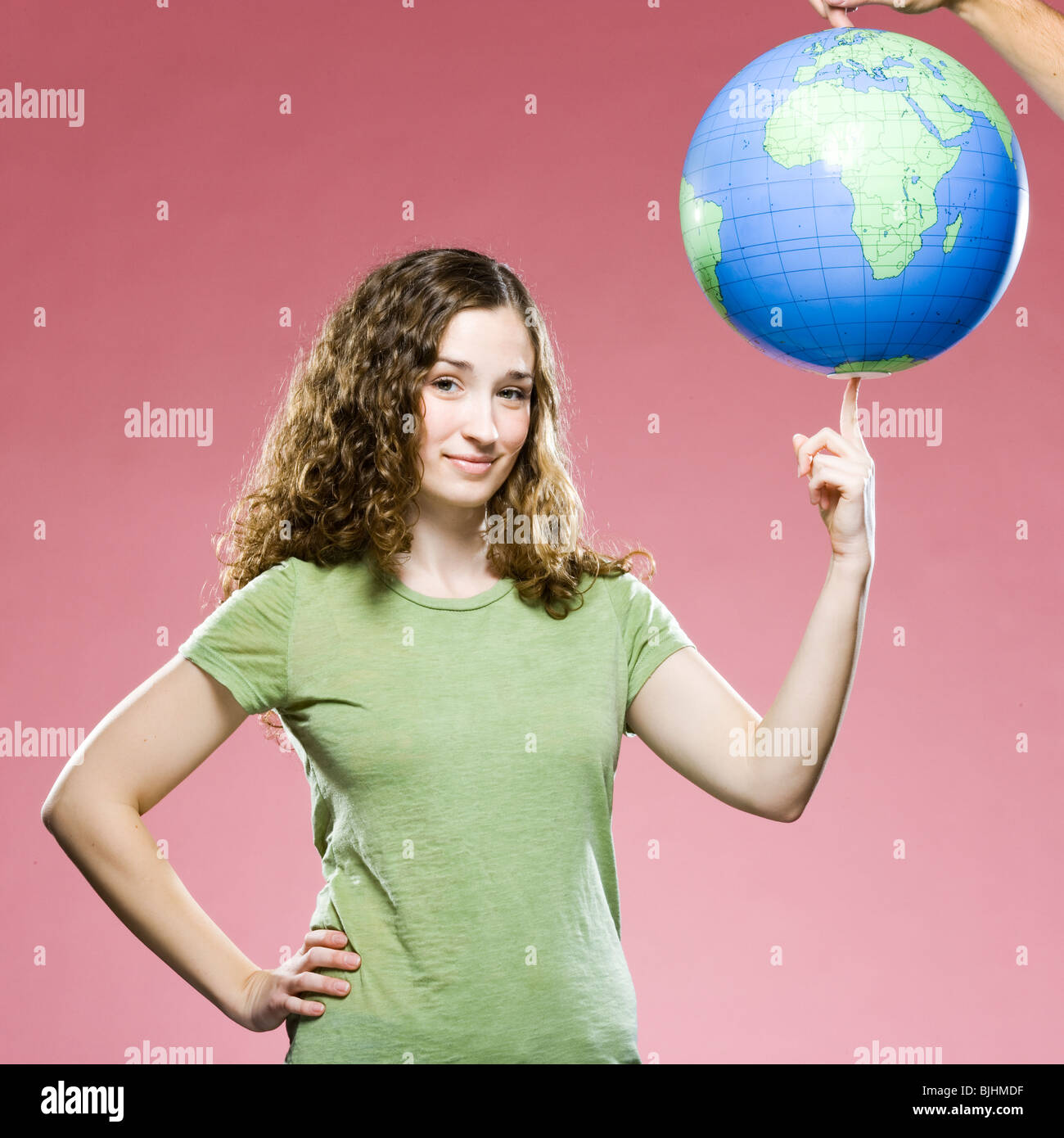 woman spinning a world globe on her finger like a basketball Stock Photo