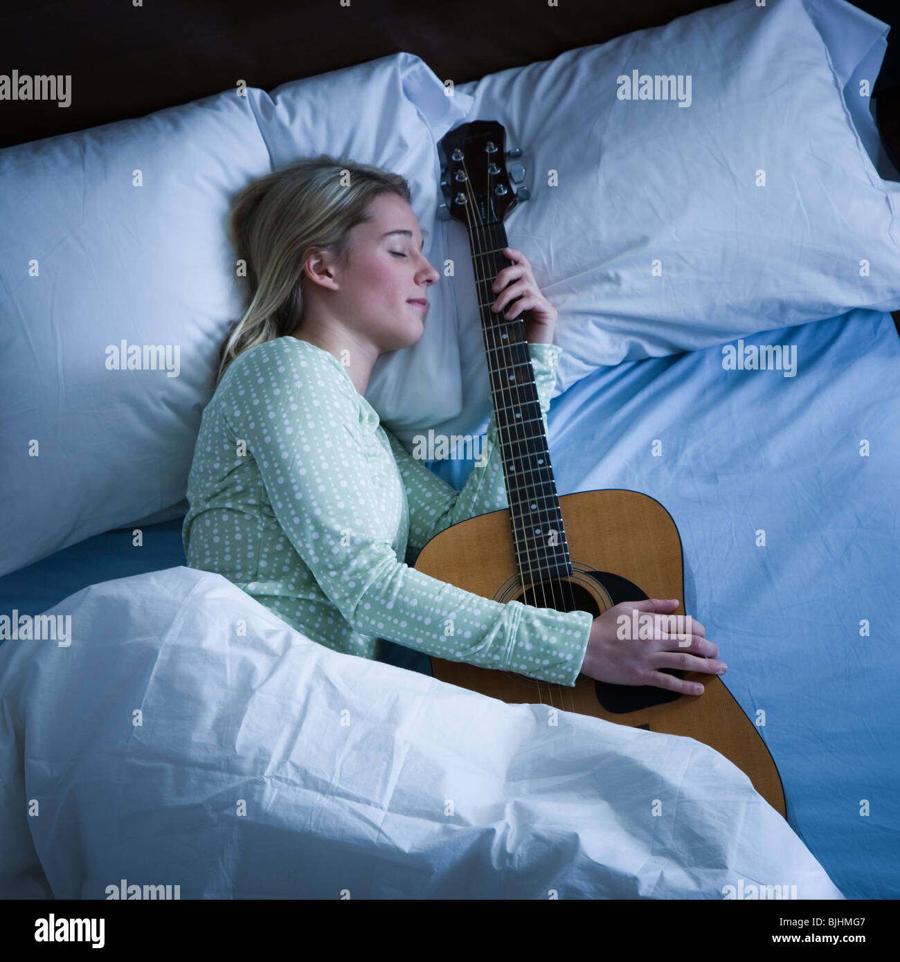 woman sleeping with her guitar Stock Photo