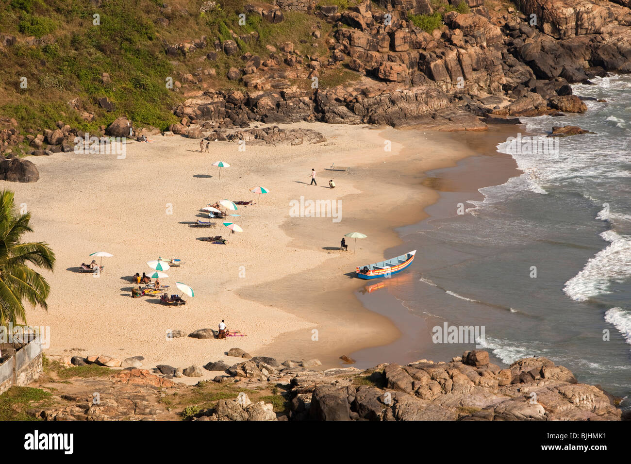 India, Kerala, Kovalam, western tourists sunbathing in secluded rocky cove by Hotel Rockholm Stock Photo