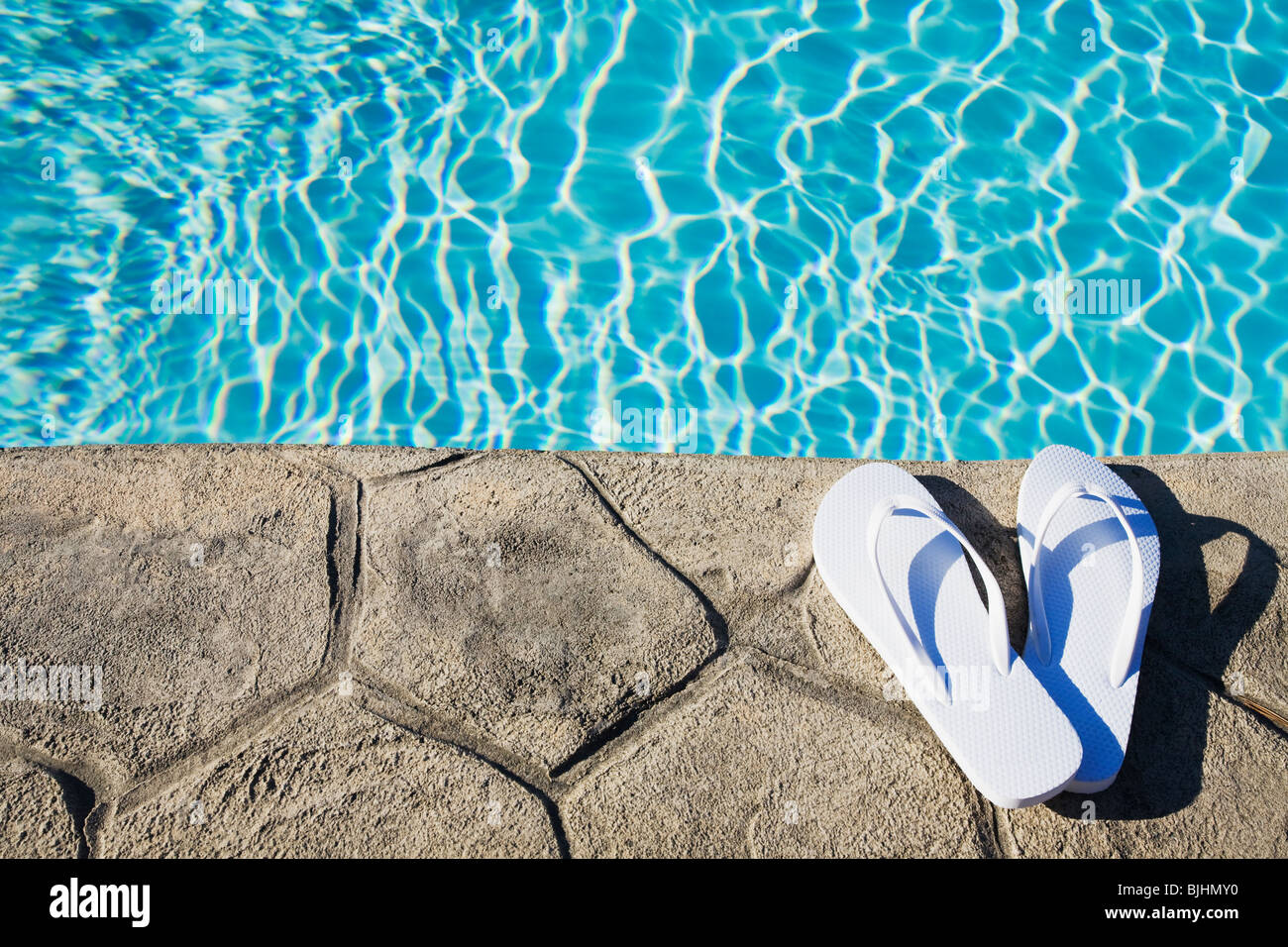 Flip flops by the pool Stock Photo - Alamy