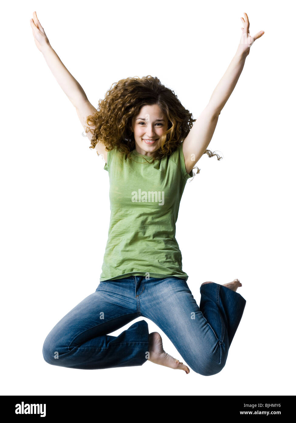 woman jumping with her arms raised in the air Stock Photo