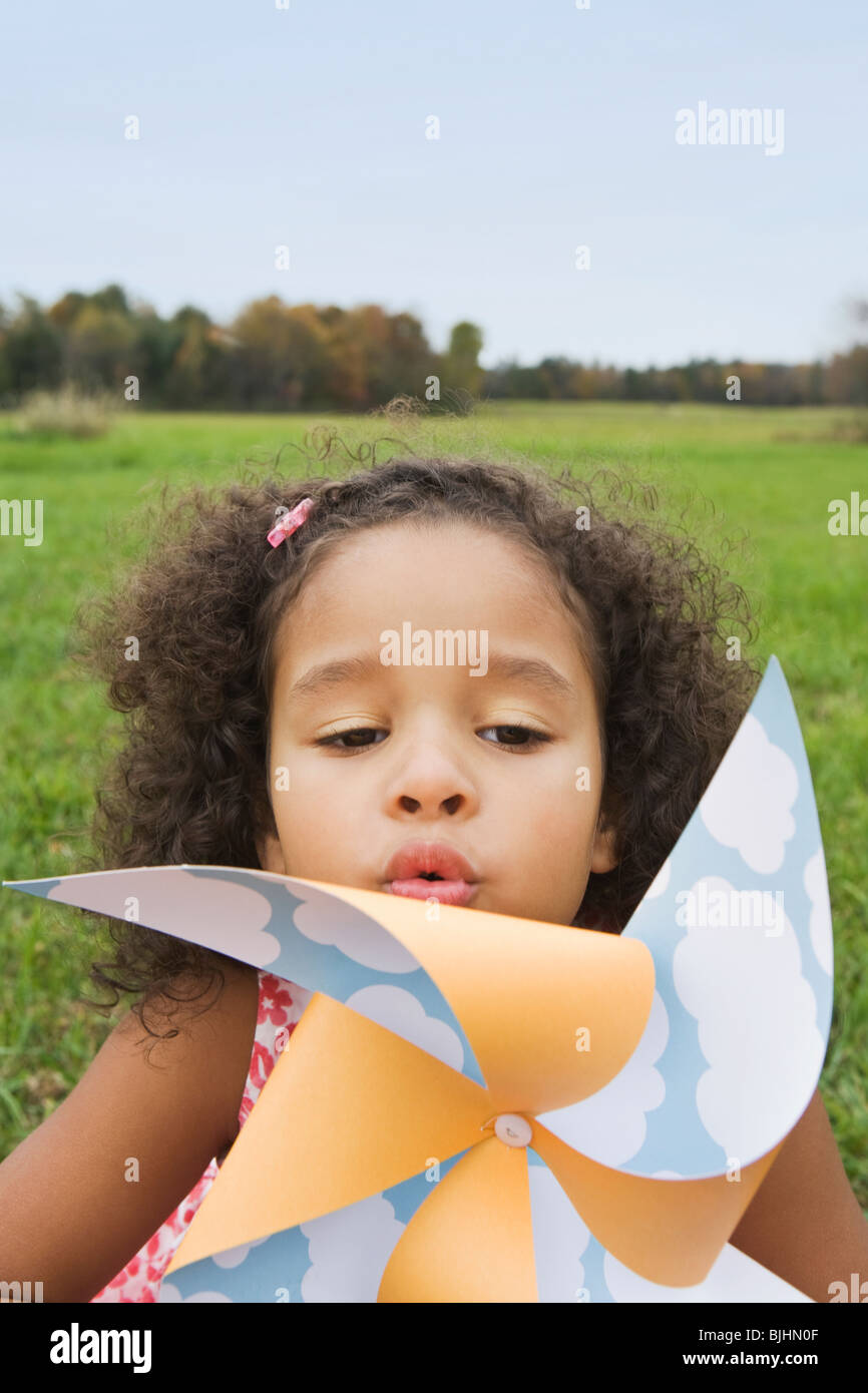 Young girl blowing toy windmill Stock Photo