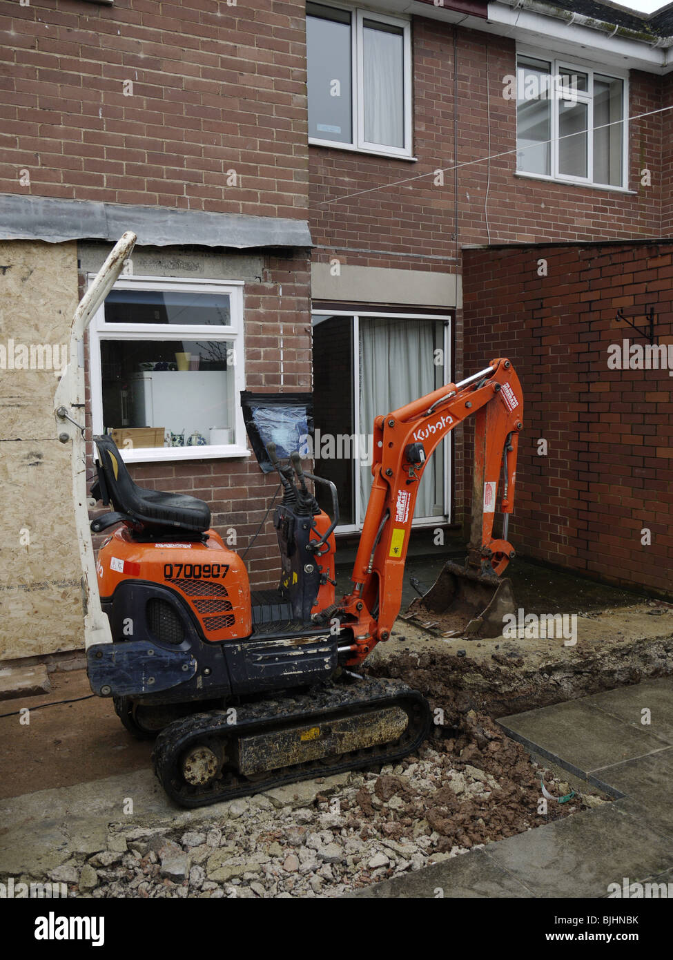 Kubota mini digger digging foundations for extension to semi-detached house uk Stock Photo