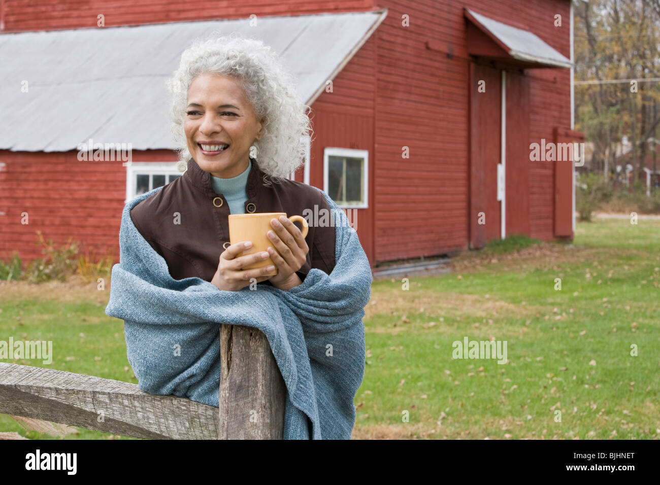 Woman holding mug outside Stock Photo