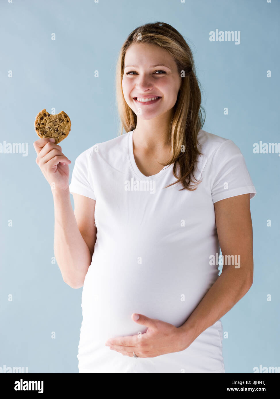 pregnant woman eating a cookie Stock Photo Alamy