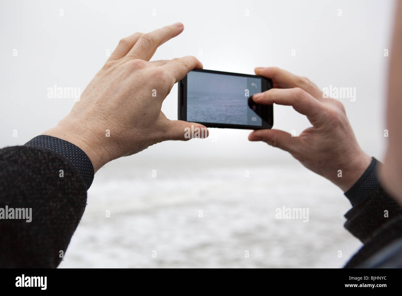 man taking photographs with a camera phone Stock Photo