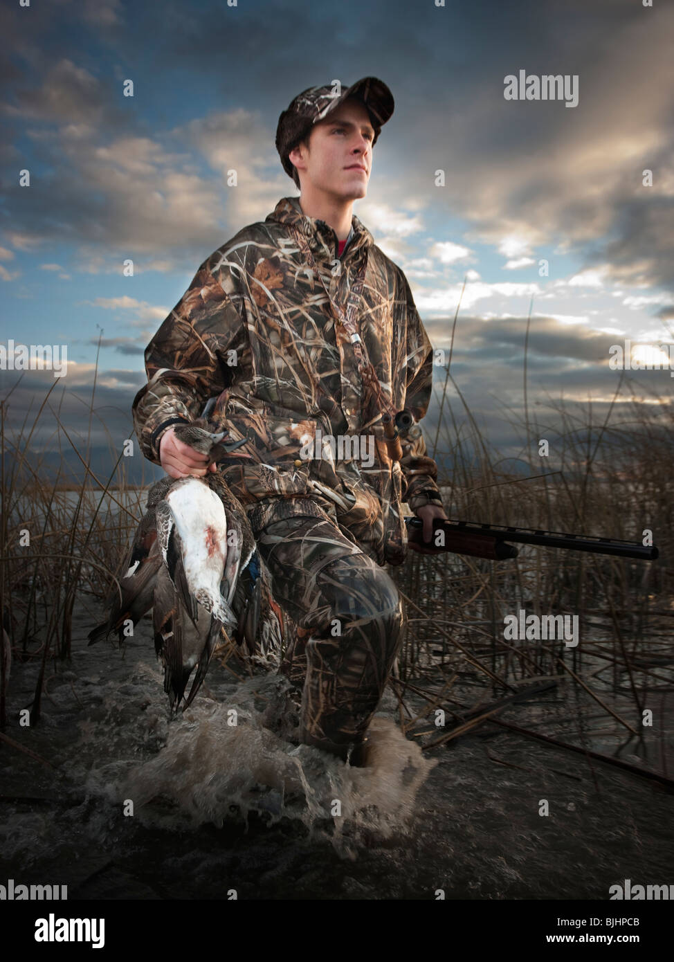 man out hunting carrying back a duck Stock Photo