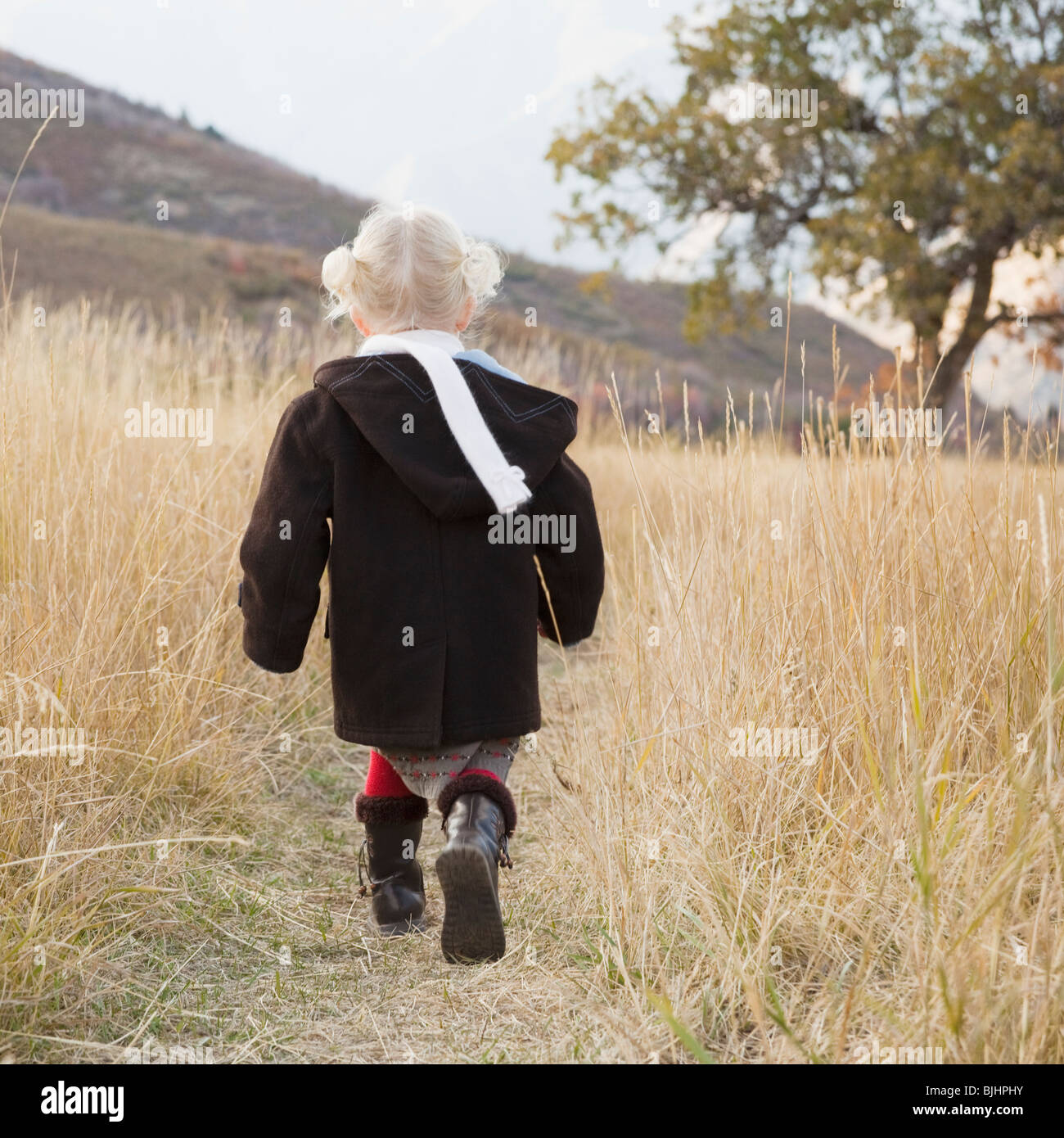 Girl walking in a meadow Stock Photo - Alamy