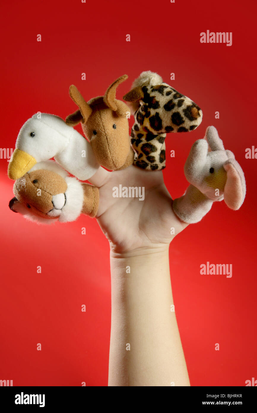 Finger puppets on a toddler hand over red background Stock Photo