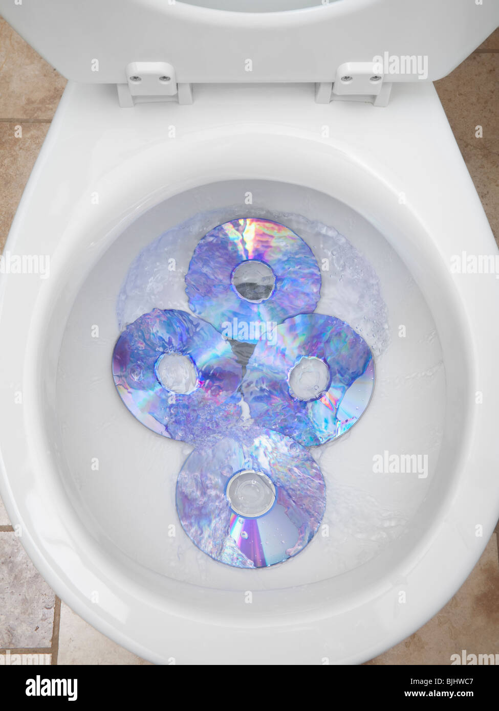 CD's in a toilet bowl Stock Photo