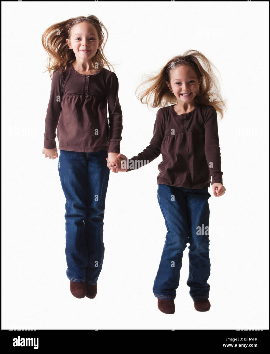 Identical twins jumping Stock Photo