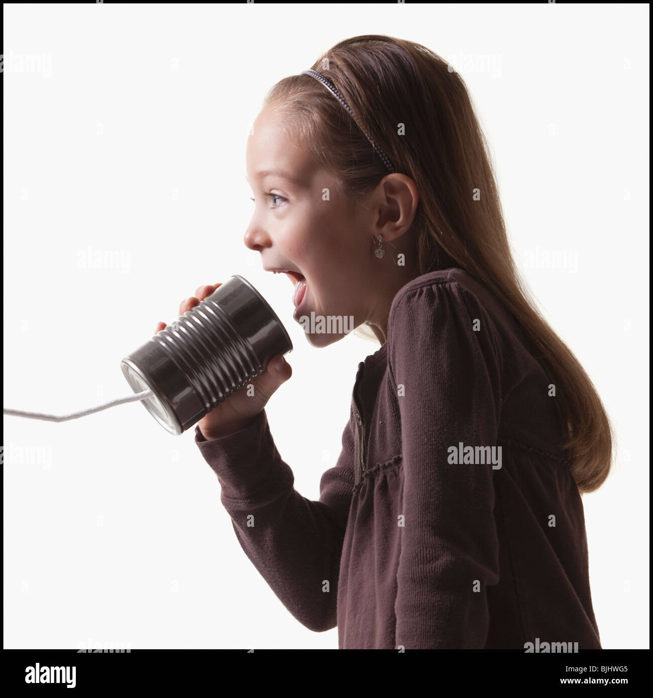 Girl playing with tin can phone Stock Photo