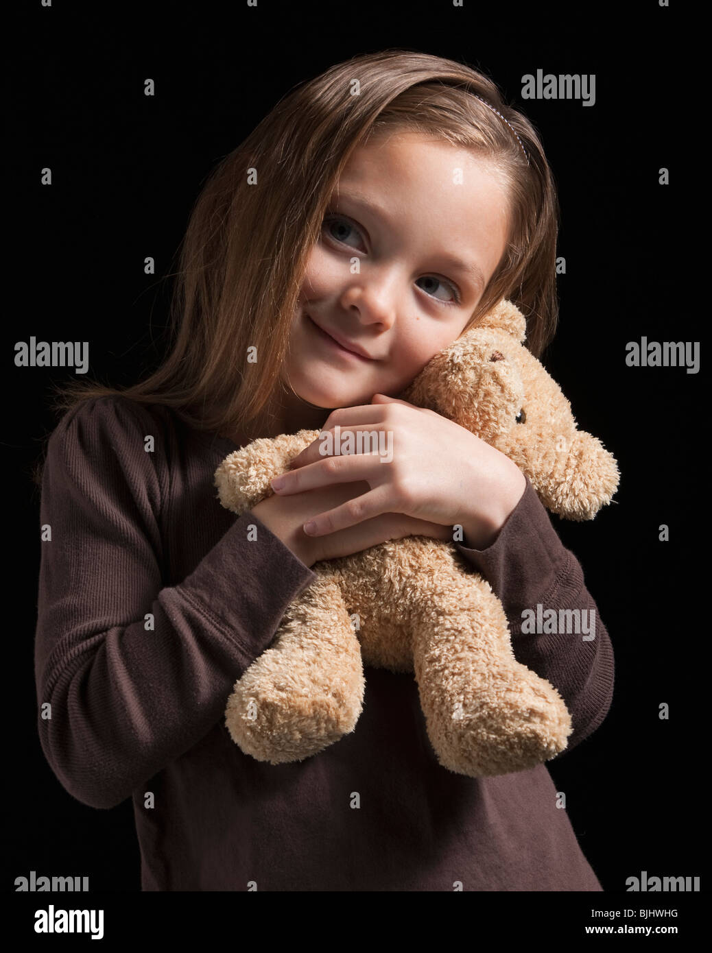Young girl hugging teddy bear Stock Photo