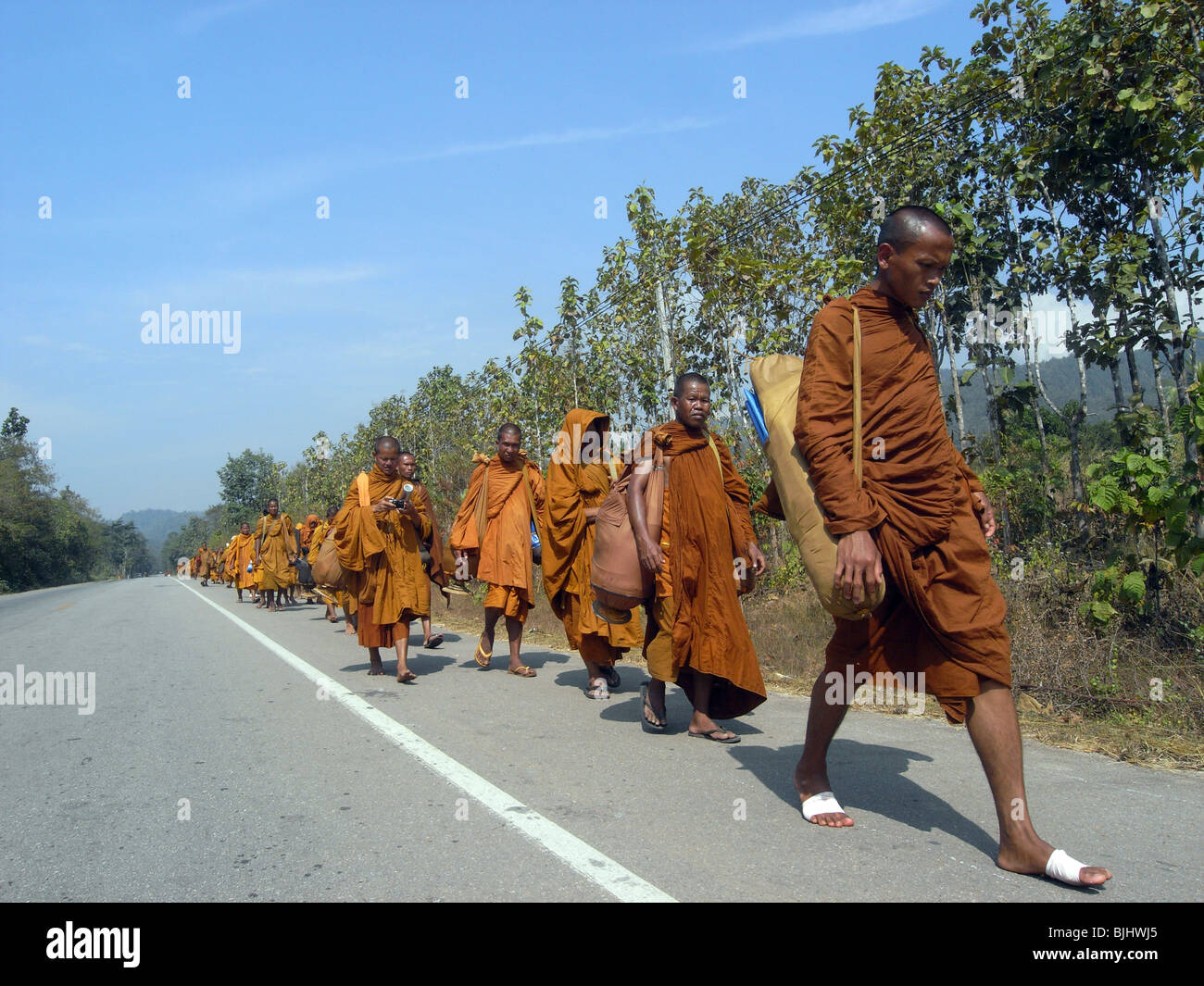 A precession of monks on the road between Mae Sot and Mae Sariang in northern Thailand, Stock Photo