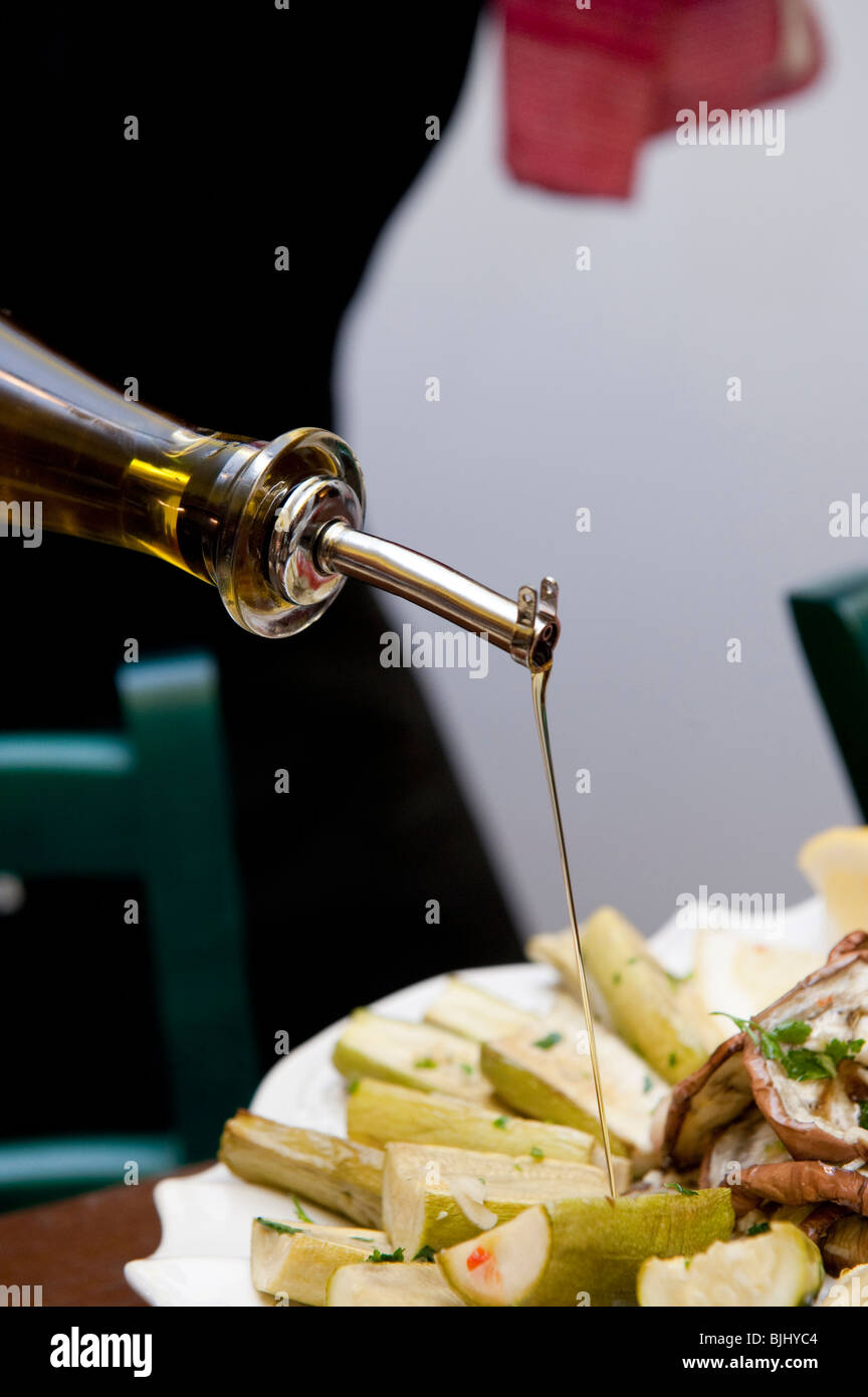 pouring olive oil on a mixed grilled vegetables Stock Photo