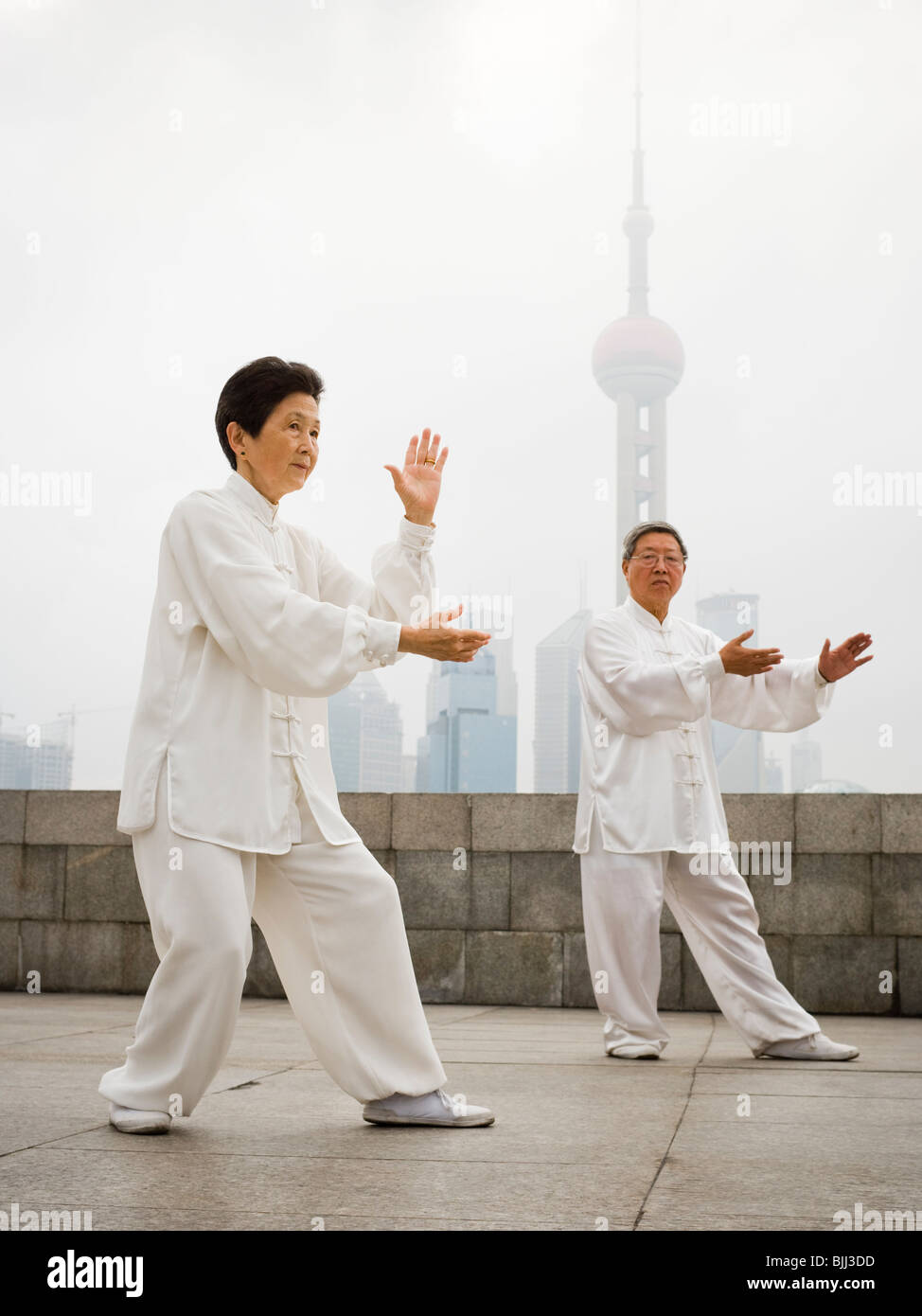 Couple doing tai chi outdoors with city skyline in background Stock ...