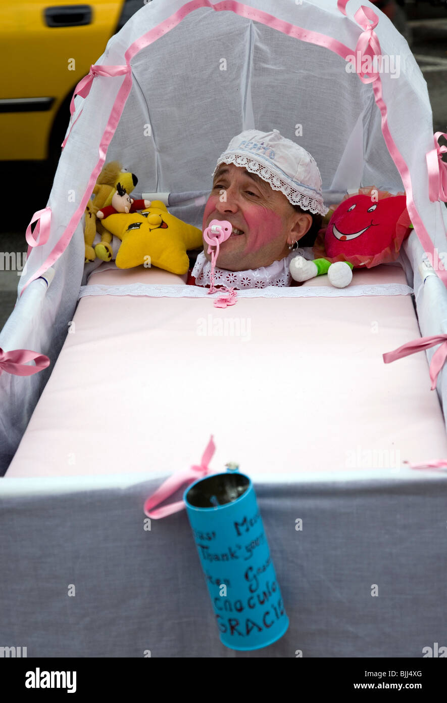 Barcelona Street Performer dressed up as baby in a crib Stock Photo