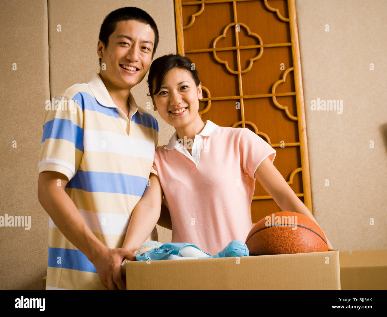 Couple with cardboard box smiling Stock Photo - Alamy