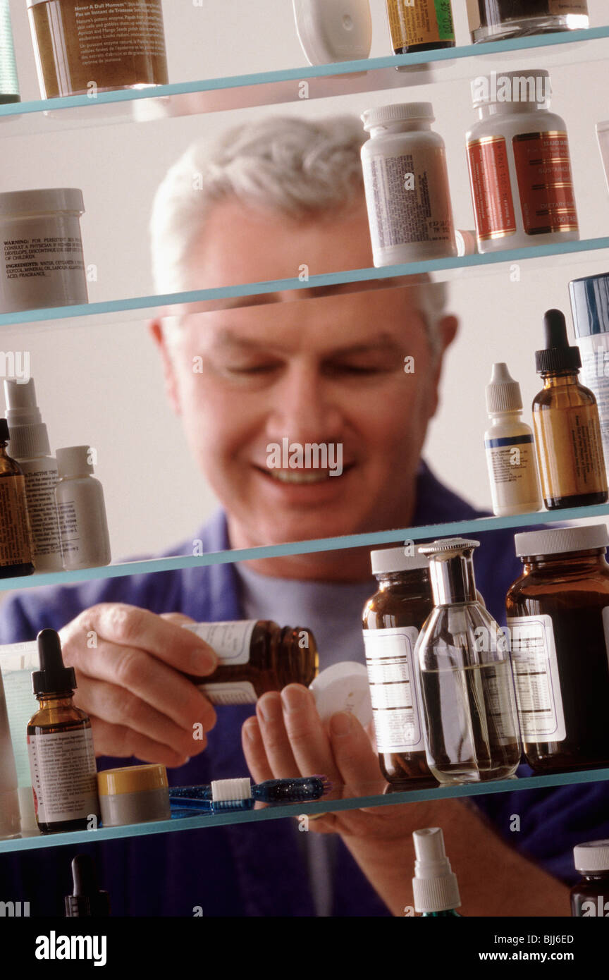 Man in front of medicine cabinet Stock Photo