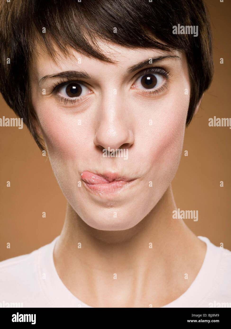 Woman making funny face with eyes crossed and puckered lips Stock Photo