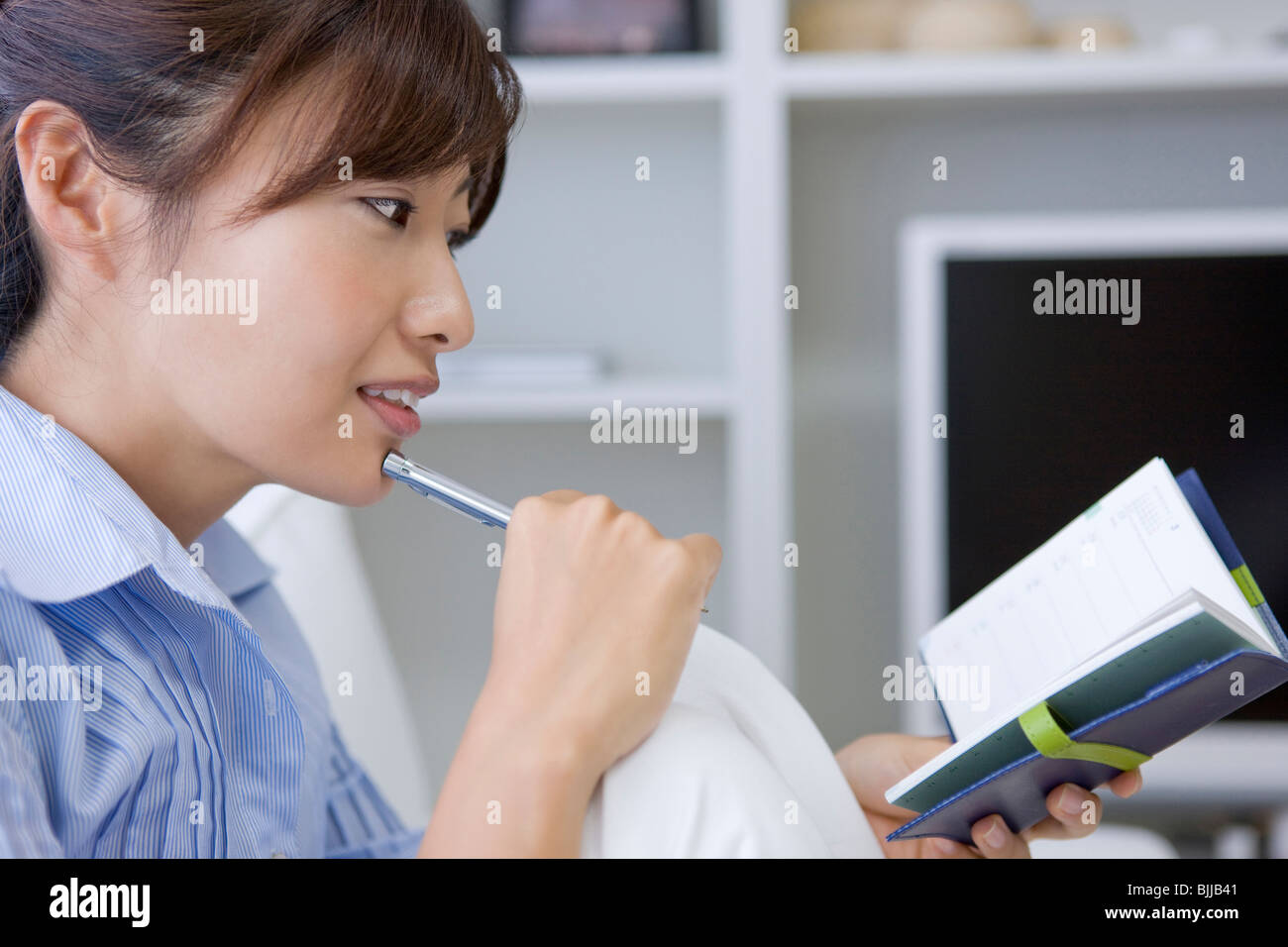 Young woman looking at personal organizer Stock Photo