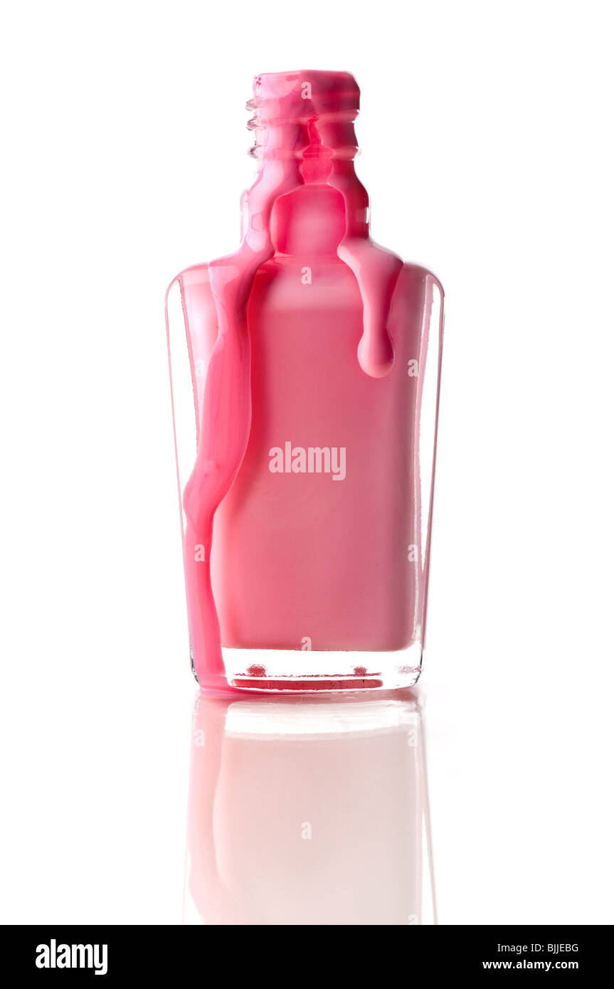 Vertical image of pink nail polish running out of a container on a reflective surface Stock Photo