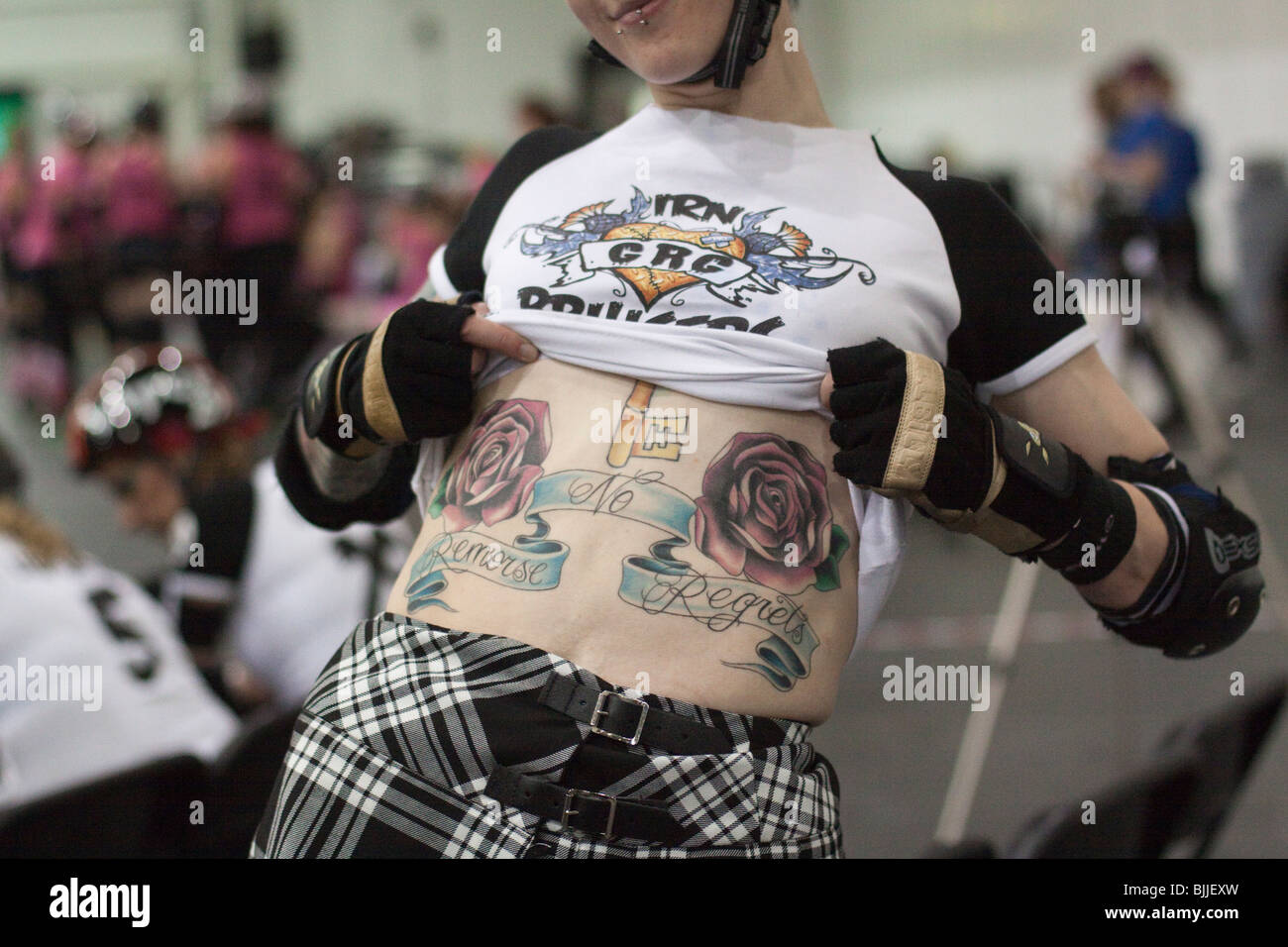 Glasgow Roller Girls roller derby girl shows off the 'No Remorse - No Regrets' tattoo on her midriff Stock Photo