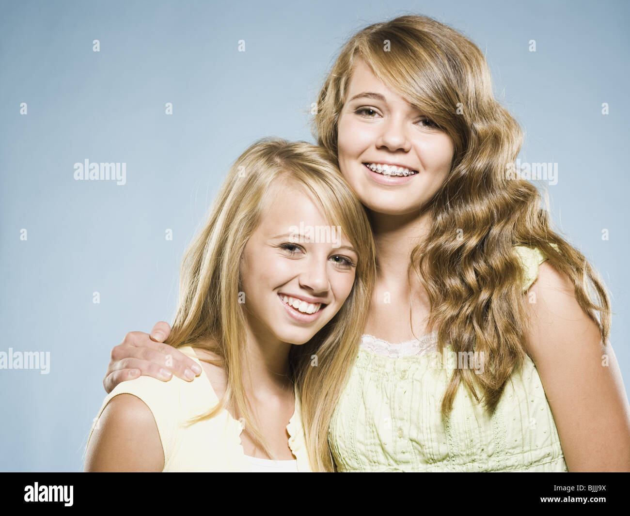 Two girls embracing and smiling Stock Photo - Alamy