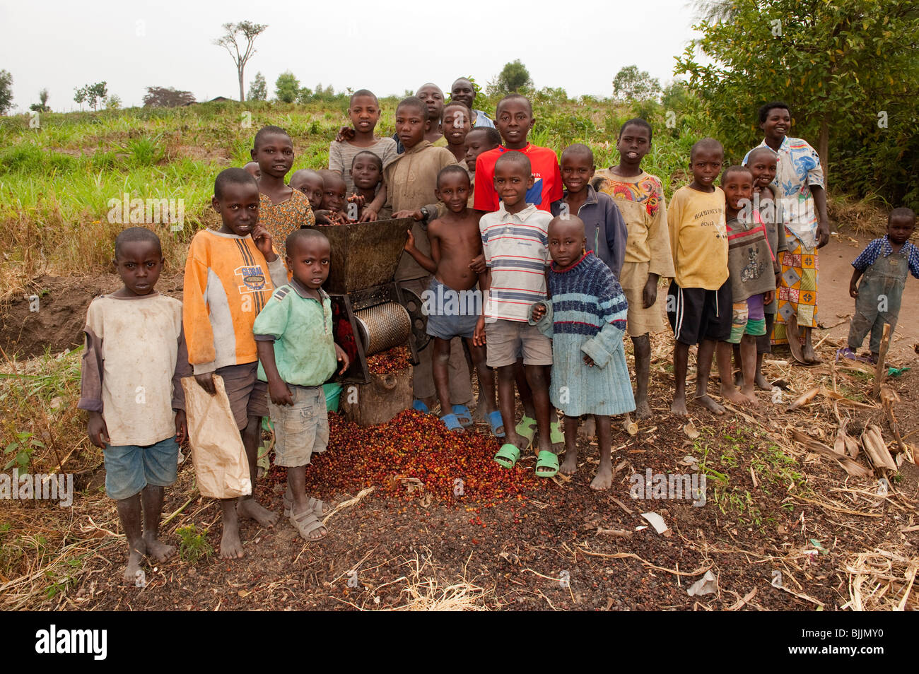 Family group around a coffee shelling machine. Rwanda Stock Photo Alamy