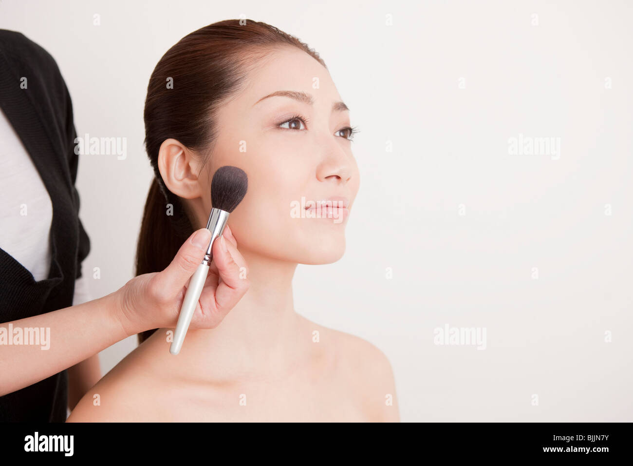 Young woman applying make up Stock Photo