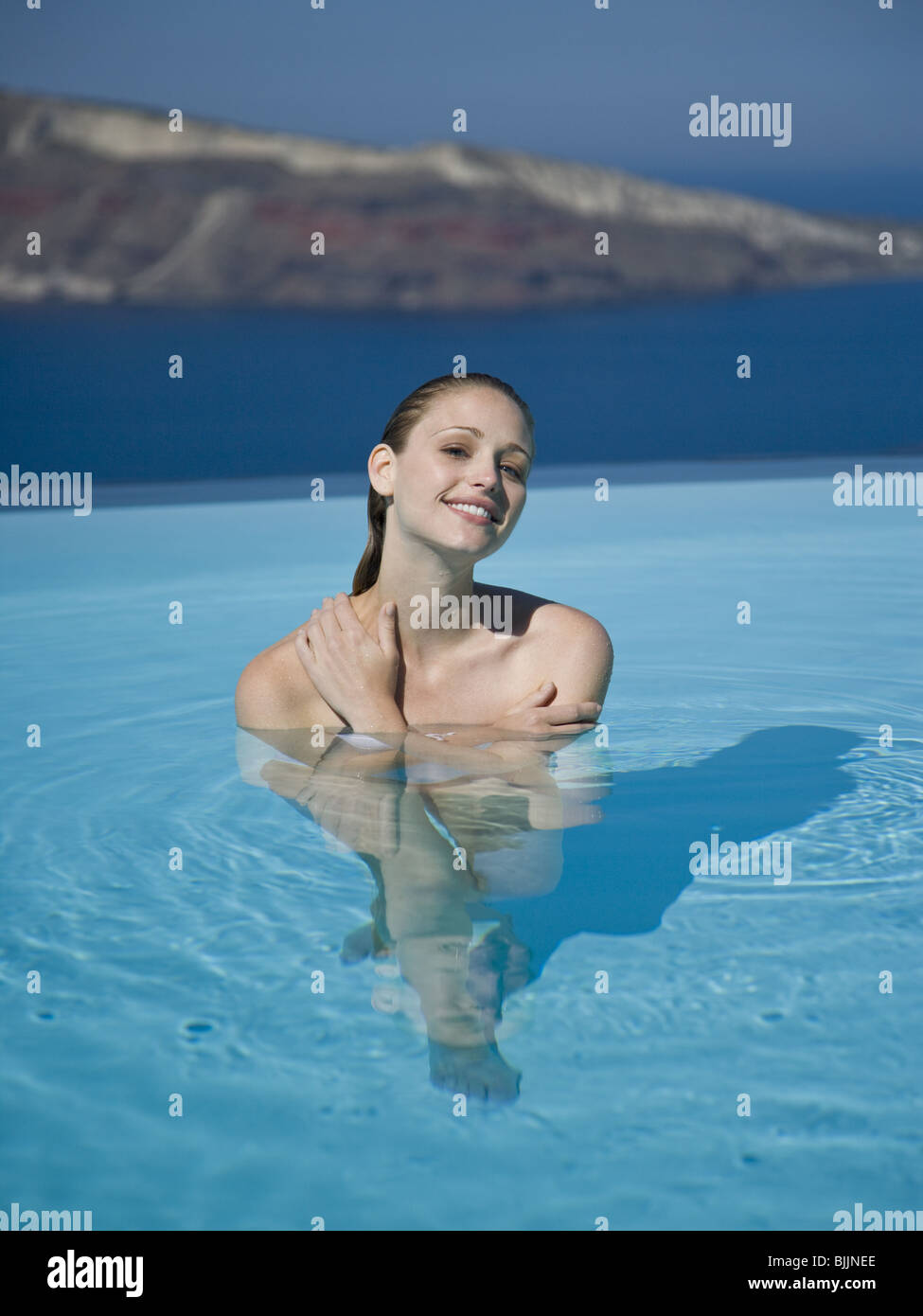 Woman in pool smiling Stock Photo