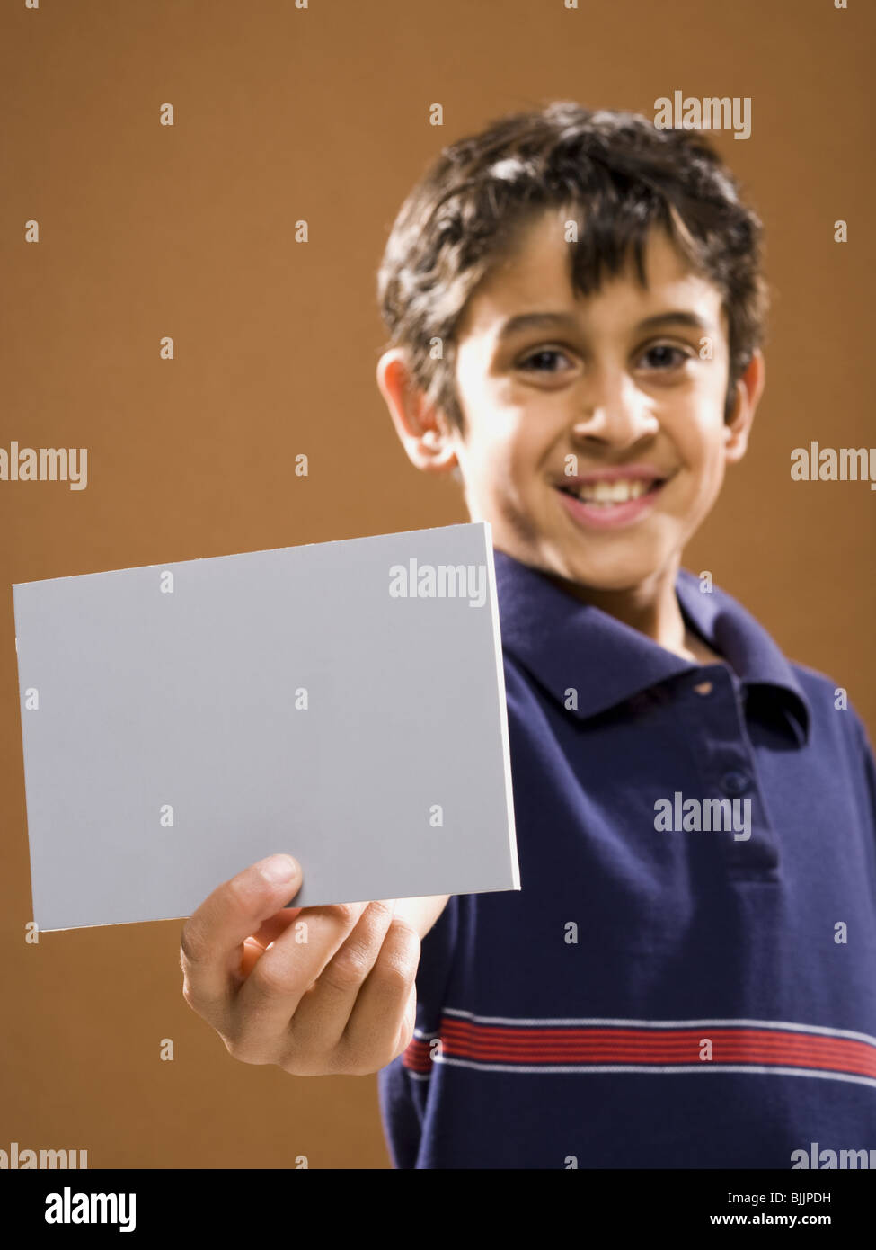 Boy holding blank card smiling Stock Photo - Alamy