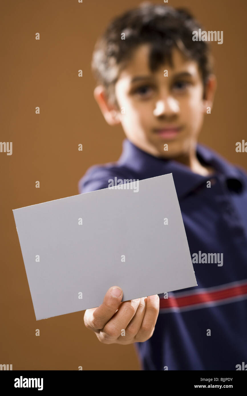 Boy holding blank card smiling Stock Photo - Alamy