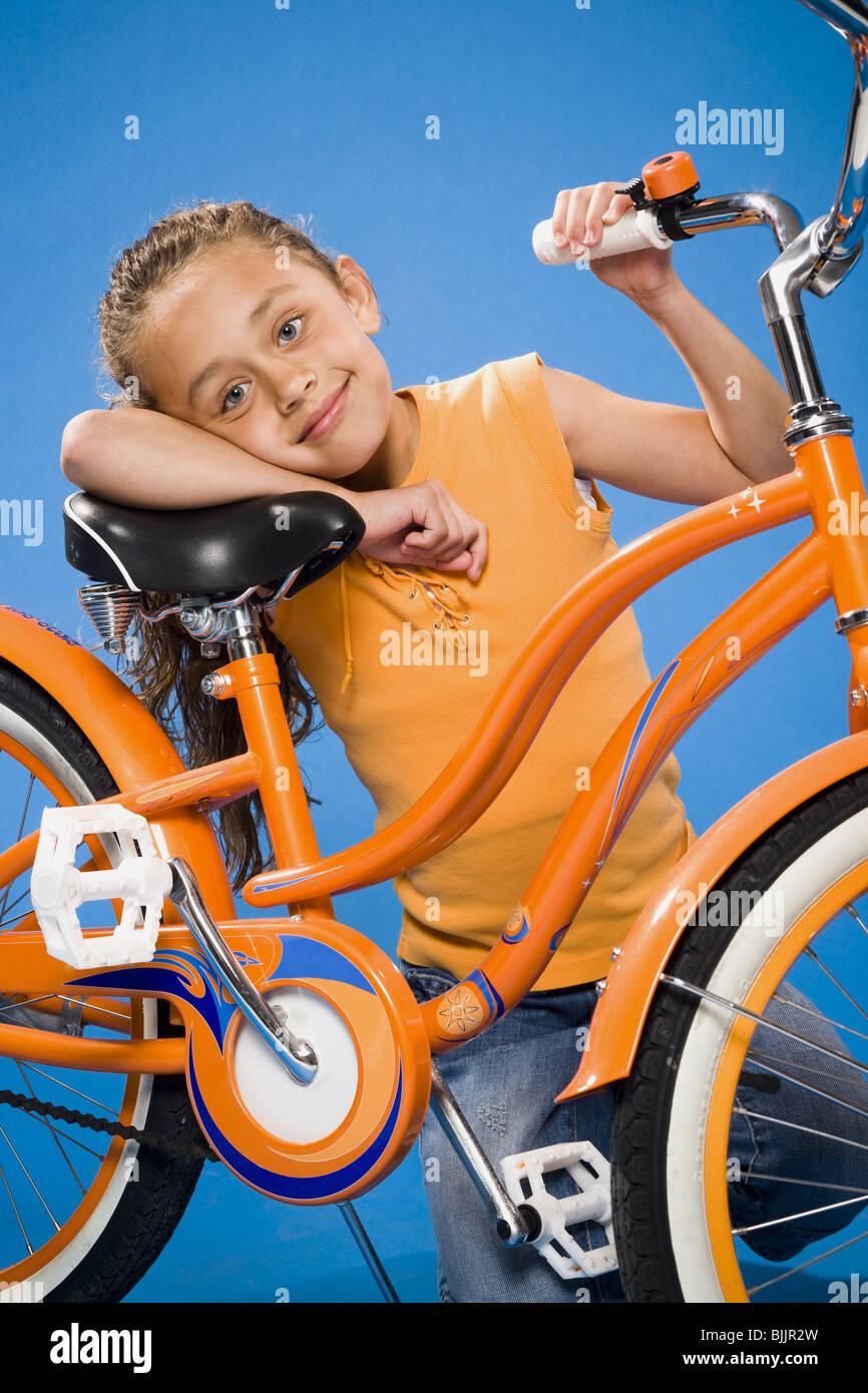 Girl on orange bicycle smiling Stock Photo