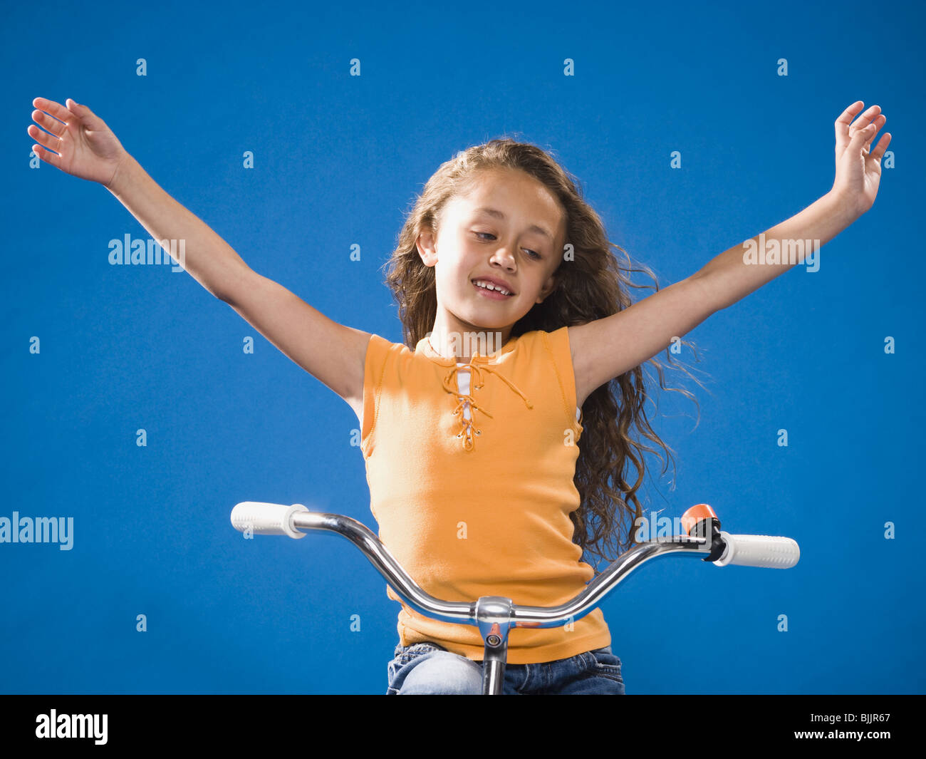 Girl riding bicycle with no hands smiling Stock Photo Alamy