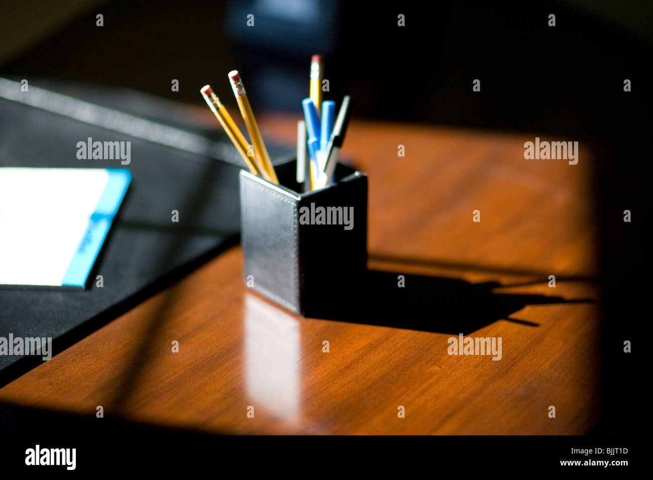 Desk with pen and pencil holder, afternoon light with shadow from ...